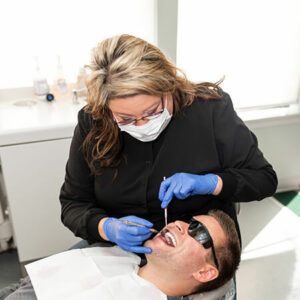 our-assistant-checking-a-patient-in-the-dentists-chair