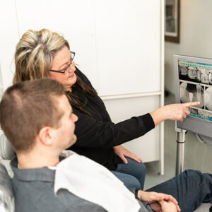 Assistant explaining to a patient at Safe Harbor Smiles