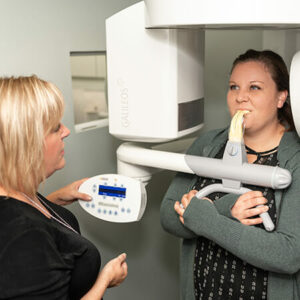 the-assistant-checking-her-patient-with-the-help-of-a-machine at Safe Harbor Smiles