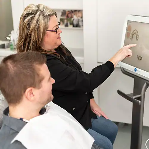 Bremerton Dentist at Safe Harbor Smiles, our-assistant-showing-something-to-his-patient-on-a-monitor - Dentist Near Me, Bremerton dentist- New Patient